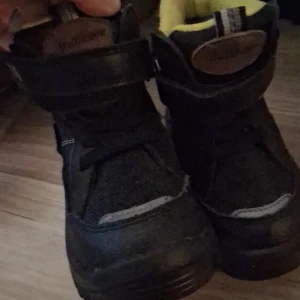 Svarta vinterkängor med ullfoder - Svarta kängor från Viking med grov sula och kardborreband. Insidan har ett mjukt, gult foder med 30% ull för extra värme. Yttermaterialet är slitstarkt och tåligt, perfekt för kalla dagar. Snygg och robust design med rund tå och platt sula.