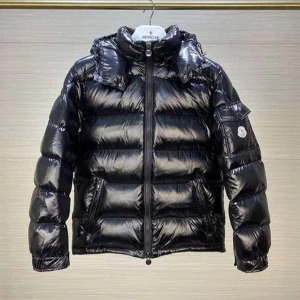 Svart pufferjacka från Moncler - Säljer en svart pufferjacka från Moncler med glansig finish och huva. Jackan har en klassisk quiltad look, dragkedja framtill och en ficka med Moncler-logga på ärmen. Perfekt för kalla dagar och riktigt snygg streetstil.