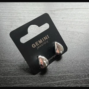 Silverörhängen från Gemini - Snygga örhängen från Gemini i blank silverfärg med droppformad design. Perfekta för dig som gillar stilrena och moderna smycken. Kommer på originalkortet och är enkla att matcha med din outfit.