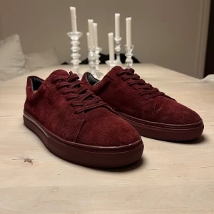 Vinröda mockasneakers från Vagabond - Snygga vinröda sneakers från Vagabond i storlek 41. Skorna har ovandel i mjuk mocka, rund tå och platt sula. Fodret är i textil och skinn, och de har klassisk snörning. Perfekt för dig som gillar stilrena och minimalistiska sneakers med en djup färgton. De är i fint skick och nypris ligger runt 1400kr.