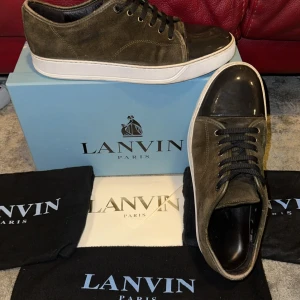 Lanvin skor - Snygga Lanvin sneakers i olivgrön mocka. Kommer med extra snören och allt som är på bilden. Ny pris ligger på 5000. Storlek Uk 10 sitter som 45