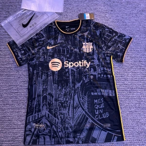 Exklusiv Barcelona Messi tröja - Limited Edition. Kan gå ner i pris vid snabb affär. FC Barcelona fotbollströja från Nike med Messi 10-tryck på ryggen. Tröjan är svart med guldiga detaljer, coolt stadsmotiv och klubbmärke på bröstet. Dri-FIT-material som andas, kortärmad och med Spotify-logga framtill. Tröjan är även en exklusiv tröja. Helt ny. 