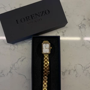 guldklocka - helt ny jättefin guldklocka från Lorenzo Milano, den är endast öppnad och har plasten kvar på både banden och själva uret😊manual och verktyg för att ta bort länkar följa med!💞nypris på klockan är:1695kr, säljer då jag ej använder och den tar bara plats😊skriv gärna vid frågor!