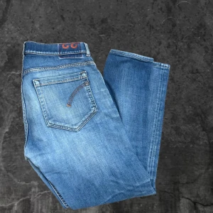 Blå skinny jeans från George - Snygga blå skinny jeans från George med slitningar på knäna och klassiska fem fickor. Jeansen har skinny fit och är tillverkade i mjukt denimtyg med orangea sömmar. Perfekta för dig som gillar en smal siluett och lite tuffare look.