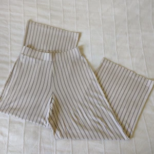 Vida stretchiga byxor med ränder, beige/svarta - Mjuka och bekväma, stretchiga byxor från Gina Tricot i en lite kortare modell. Storlek XS. 95% viskos och 5% elastan. Sparsamt använda. 