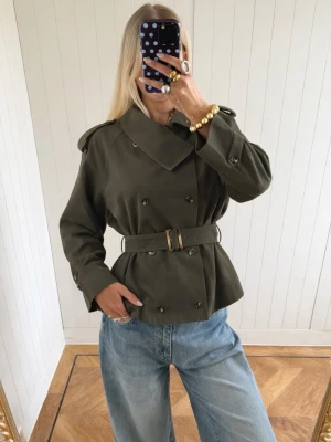 Olivgrön trenchcoat med bälte - Snygg grön trenchcoat med bälte i midjan✨I fint skick, passar en xs/s