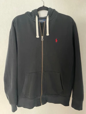 Hoodie Polo Ralph Lauren  - Hoodie Polo Ralph Lauren 🧥  This is a dark hoodie from Polo Ralph Lauren, featuring a red embroidered logo. It appears to be in very good condition with no visible flaws.  ⭐️ Condition: 9/10 🎲 Size: L/G 📦 Fast and careful shipping