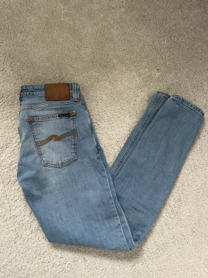 Ljusblå nudie jeans 30/32 - Säljer dessa nudie jeans i nyskick! Storlek 30/32. Mitt pris 400kr! Passa på nu vid fri frakt! En vecka kvar!