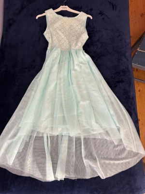 Ljusblå klänning  - Elegant ljusblå långklänning. Ärmlös modell med rund halsringning och mjukt fall. Barnstorlek 170 (S). 