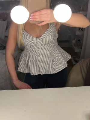 Randig peplumtop med knappar - Säljer min super fina randiga topp med knappar framtill, den har smala axelband som går att spänna åt💞storlek s men funkar perfekt som xs också💞