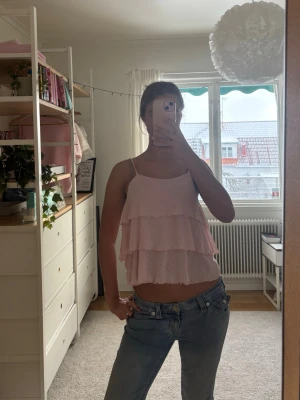 Ljusrosa volangig linnetopp🩷 - Säljer en söt ljusrosa linnetopp med tunna axelband och flera lager volanger. Toppen är ärmlös och har en luftig, flowy passform som känns riktigt somrig. Perfekt att styla med jeans eller kjol för en snygg outfit !!  🩷🩷