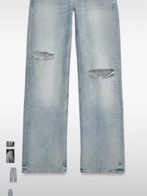 Lågmidjade jeans med slitningar - Säljer ett par ljusblå jeans och slitna detaljer vid knäna. Jeansen har en avslappnad passform och klassisk femficksdesign. Perfekta för en trendig och avslappnad look. Materialet är denim i bomull. Jeansen är helt oanvända men prislappen har hunnits tagit bort