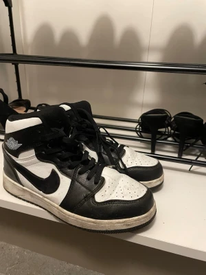 Nike Air Jordan 1 svartvita sneakers - Svartvita Nike Air Jordan 1 sneakers med klassisk high-top design. Använda. Storleken är mer som 39