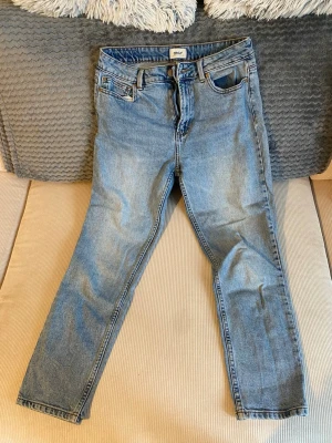 Blå jeans från ONLY - Säljer ett par klassiska blå jeans från ONLY med fem fickor och normal midja. Jeansen har en ljus tvätt och raka ben, perfekta till en avslappnad stil. Materialet är mjukt denim som sitter skönt hela dagen.