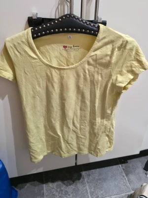 Gul basic t-shirt från bpc bonprix - En ljusgul basic t-shirt från bpc bonprix collection. T-shirten har rund halsringning och korta ärmar, tillverkad i mjuk bomull. Perfekt för en enkel och avslappnad stil.