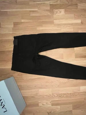Svarta jeans från J.Lindeberg - Snygga svarta jeans från J.Lindeberg med klassisk femficksdesign och diskret JL-logga på myntfickan. Jeansen har smal passform och är tillverkade i ett mjukt, stretchigt material som sitter skönt hela dagen. Prisen går att diskuteras tveka inte 