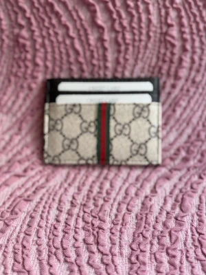  korthållare  - . Svarta detaljer upptill och plats för flera kort. Perfekt accessoar för dig som gillar lyxig och stilren design.