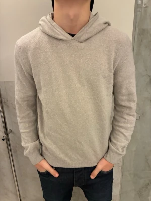 Oscar Jacobson hoodie  - Stickad hoodie från Oscar Jacobson i färgen beige. Den är i storlek S och är bra skick, inga defekter. Stilren och skön, perfekt för vintern. Hör av er vid frågor!