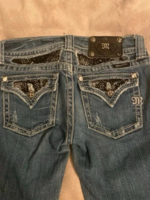 Miss Me Jeans - Funderar på att sälja dessa sjukt snygga jeans från Miss Me jeansen i bootcut-modell och låg midja. Innerbenslängden är ca 75-76cm och midjemått (rakt över) är ca 35-36cm💗mycket bra skick💗PRIS GÅR ATT DUSKUTERA, skriv prisförslag 💗