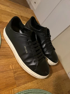 Svarta Axel Arigato sneakers i läder - Stilrena svarta sneakers från Axel Arigato i slätt läder med svart snörning och vit sula. storlek 37,5. priset kan diskuteras kom med prisförslag.