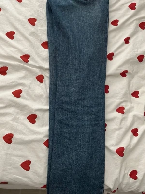 Blå raka jeans från ginatricot  - Säljer ett par klassiska blå raka jeans från ginatricot . Jeansen har fem fickor, bälteshällor och stängs med dragkedja och knapp. Materialet är denim i 100% bomull och färgen är en snygg mellanblå tvätt. Perfekta till en avslappnad stil.