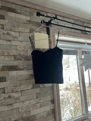 Blå  croppad linnetopp - Snygg blå croppad linnetopp med tunna axelband och enkel design. Perfekt att matcha med höga jeans eller kjol. Materialet känns mjukt och stretchigt, vilket gör toppen bekväm att bära hela dagen.