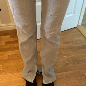 Gråa Weekday jeans med slits - Mycket bra skick! Endast liten defekt(se bild 4). Grå jeans från Weekday med raka ben och slits nertill. Femficksmodell i mjukt jeanstyg. Stl 26/32. 