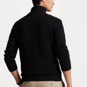 Svart stickad half zip-tröja Polo Ralph Lauren - Svart stickad tröja från Polo Ralph Lauren med röd broderad logga på bröstet. Hög krage och half zip-dragkedja. Perfekt för lager-på-lager och snygg till både skjorta och t-shirt. Ny pris 2700kr mitt pris 1100