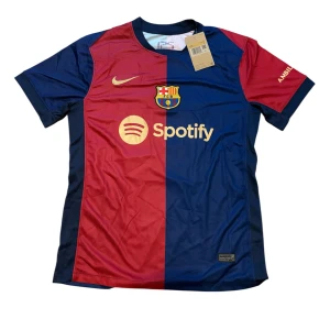 FC Barcelona Raphinha 11 matchtröja Nike - Säljer en officiell FC Barcelona fotbollströja från Nike med Raphinha 11 på ryggen. Tröjan är kortärmad och har klassiska blå och röda paneler, klubbmärke broderat på bröstet och sponsorer i gult. Tillverkad i lätt och ventilerande polyester.