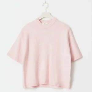 Ljusrosa stickad tröja med kort ärm från gina - Superfin ljusrosa stickad tröja med korta ärmar och rund hals. Tröjan har en avslappnad passform och ribbade kanter vid hals, ärmslut och nederkant. Perfekt för lager-på-lager och en söt touch till din outfit.