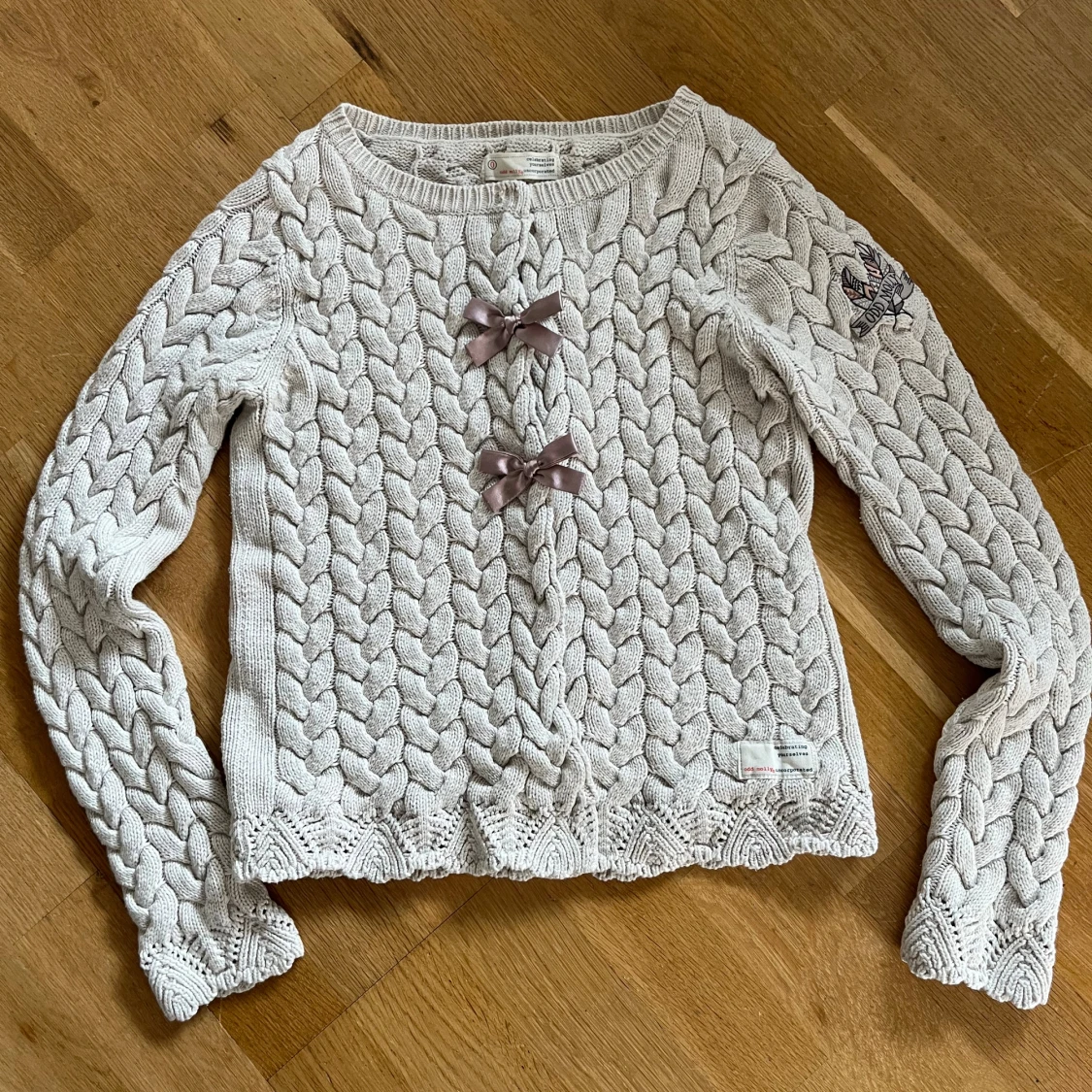 Beige stickad tröja Odd Molly med rosetter