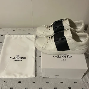 Valentino Garavani Open sneakers - Snygga Valentino Garavani Open. Klassisk rund tå, vita snören och ikoniska nitar baktill på sulan. Kommer med originalkartong och dustbag. Perfekta för dig som gillar exklusiva och stilrena sneakers.
