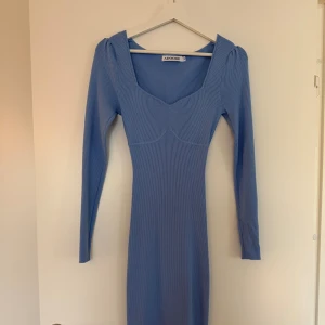 Blå ribbad långärmad klänning Adoore - Supersnygg blå ribbad klänning från Adoore med lång ärm. Klänningen har en smickrande v-ringning och figurnära passform, den sitter super smickrande men kommer inte till användning längre💕