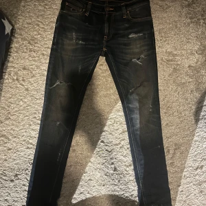 Vintage Nudie jeans - Feta jeans från Nudie med en jävligt snygg design med slitningar och lite washed look med en slim fit. Perfekt för hösten.