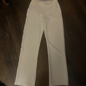 Vita kostymbyxor - Snygga vita kostymbyxor med raka ben och klassisk passform!  Byxorna har hällor för bälte och diskreta fickor framtill. Inte använda!☺️