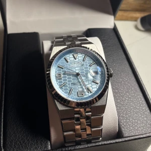 Seiko Land-Dweller mod - Helt nybyggd Seiko Land-Dweller Mod Helt ny modell!  Specifikationer: Storlek: 40mm Urverk: Nh35 (Automatiskt)  Material: 904L Rostfritt Stål Glas: Sapphire Glas Datumvisare Boett: Räfflad Bezel Tavla: Ljusblå Armband: Nya Flat Jubilee armbandet  Krona: Screw Down Vattentålighet: 30 Meter Klocklåda ingår