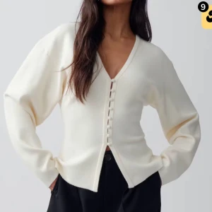 Stickad kofta - Snygg krämvit kofta med v-ringad hals och knappar framtill. Använd väldigt få gånger