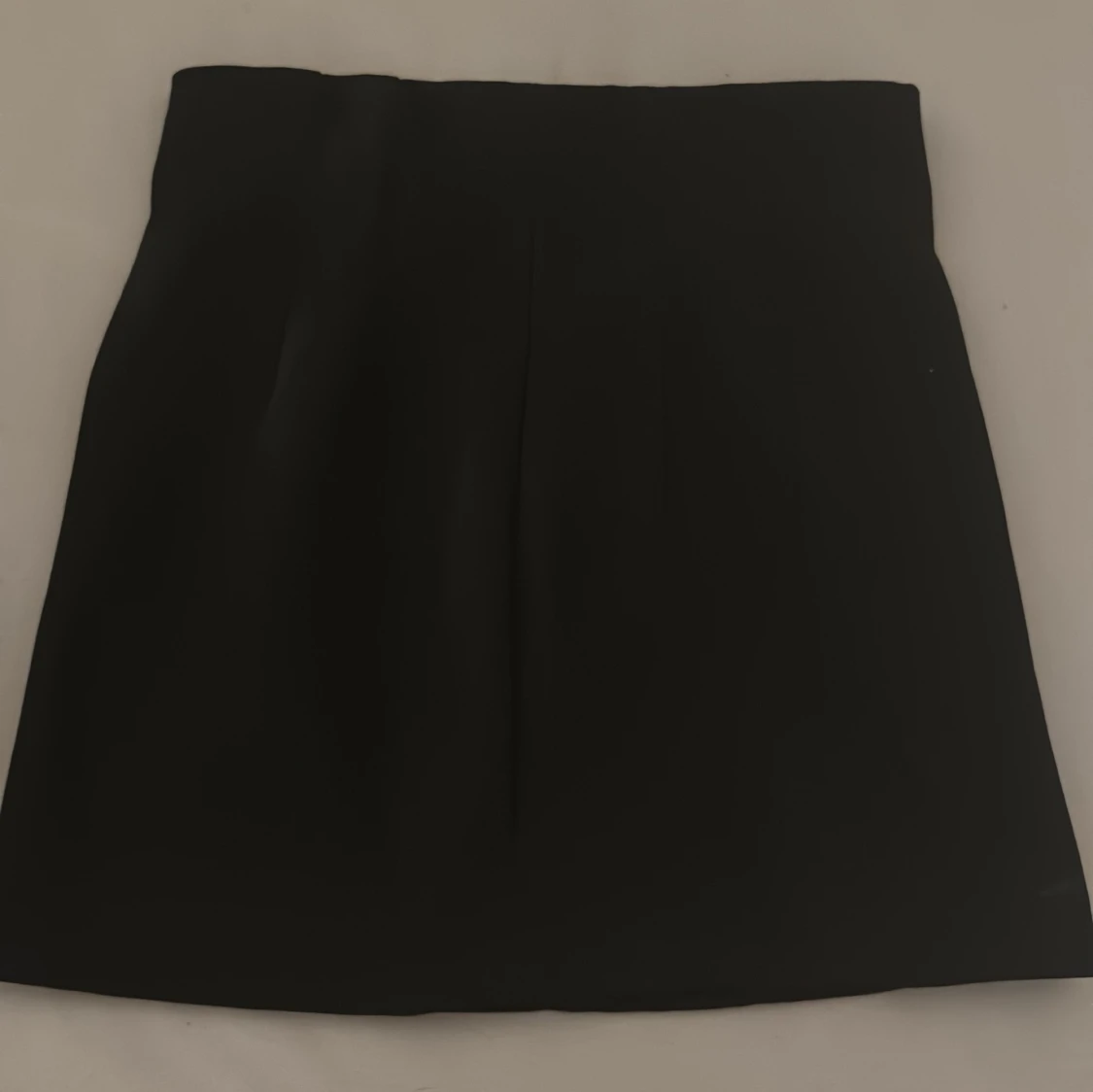 Svart kortkjol med dragkedja