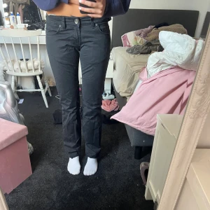 Svarta bootcut jeans från LTB - Svarta jeans från LTB med klassisk femficksdesign och snygga detaljer på bakfickorna. Modellen har bootcut-snitt och normal passform. Jeansen är tillverkade i bomull med lite stretch för extra komfort. Perfekta för dig som gillar en tidlös look med lite edge.