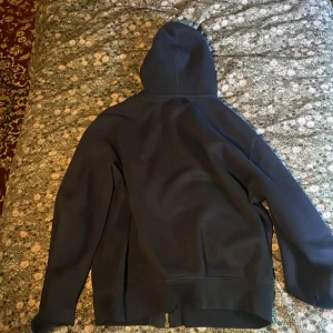 Mörkblå hoodie från Ralph Lauren. Öppen till diskussion om pris  - Fri Frakt. Mörkblå hoodie från Ralph Lauren med dragkedja och huva. Klassisk design med vit snörning i huvan och röd broderad logga på bröstet. Mjuk bomullskvalitet och fickor framtill. Perfekt för chill dagar eller när du vill vara casual.