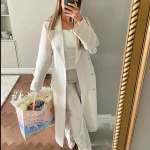 Beige linnekappa NA-KD - Beige lång trenchcoat i linnematerial från NA-KD 🤍(inte mina bilder) Superfin passform, sitter snyggt och känns lyxig! Använd fåtal gånger– i NYSKICK!. Nypris: 1300 kr.