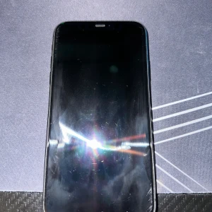 iPhone 11 64GB Black - Säljer en svart iPhone 11 med 64GB lagring. Telefonen har synliga repor på framskärmen men inget som märks vid användning. Mobilen har dessutom en spricka vid kameran på baksidan men ingenting som påverkar. Levereras med originalkartong. Perfekt för dig som vill ha en prisvärd iPhone med bra prestanda. Mobilens batterihälsa ligger på 73% och behövs bytas ut men fungerar annars som den ska.