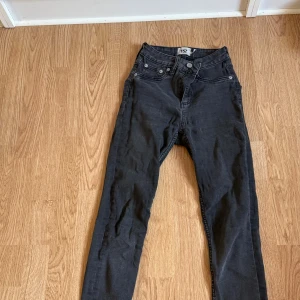 Svarta jeansbyxor 157 skinny fit - Svarta jeansbyxor från 157 med skinny fit och klassisk femficksdesign. Byxorna har hög midja och raka ben, tillverkade i mjukt jeanstyg med stretch för skön passform. Perfekta för dig som gillar en smal siluett och enkel stil.
