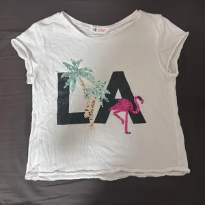 Vit t-shirt med paljetter - Vit t-shirt med stort LA-tryck framtill