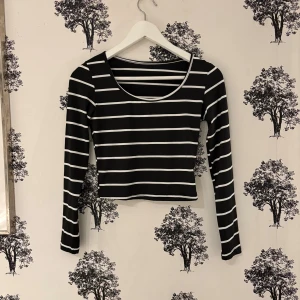 Svartvit randig långärmad topp Shein - Säljer en svart långärmad topp från Shein med vita horisontella ränder. Toppen är croppad med rund halsringning och har en slim passform. Perfekt för att skapa en cool och enkel look.