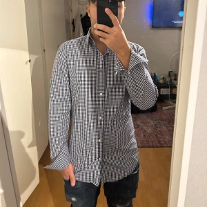 Blårutig slim fit skjorta från H&M - Snygg blårutig skjorta från H&M i slim fit-modell. Skjortan har klassisk krage, vita knappar och långa ärmar med manschett. Tillverkad i bomull och är lätt att stryka. Perfekt för dig som gillar stilrena och moderna plagg med lite edge.
