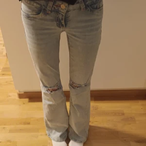 Bootcut jeans med slitningar från Nelly - Intressekoll på mina jeans. Bootcut jeans från Nelly i ljusblå tvätt med slitna detaljer vid knäna och broderade bakfickor. Klassisk femficksmodell med knapp och dragkedja framtill. Snyggt broderi i rosa på bakfickorna. Nypris 699 kr.