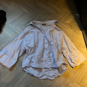 Ljusblå skjorta från Zara - Ljusblå skjorta från Zara med knappar framtill. Skjortan har trekvartsärmar. 