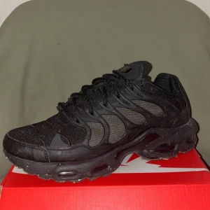 Nike Air Max svarta sneakers - Svarta Nike Air Max sneakers med chunky sula och synliga luftkuddar. Ovandelen är i mesh och syntet med coola detaljer och snörning. Sulan har ett unikt prickigt mönster undertill. Perfekt för dig som gillar sportig och modern stil.