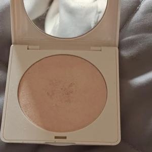 H&M Golden Pearl Highlighter - Highlighter i nyansen Golden Pearl från H&M. Kommer i en stilren, ljusbeige kompakt dosa med spegel. Pudret har en skimrande, ljusguldig ton som ger glow till ansiktet. Använd några gånger men i helhet ser produkten ut som ny